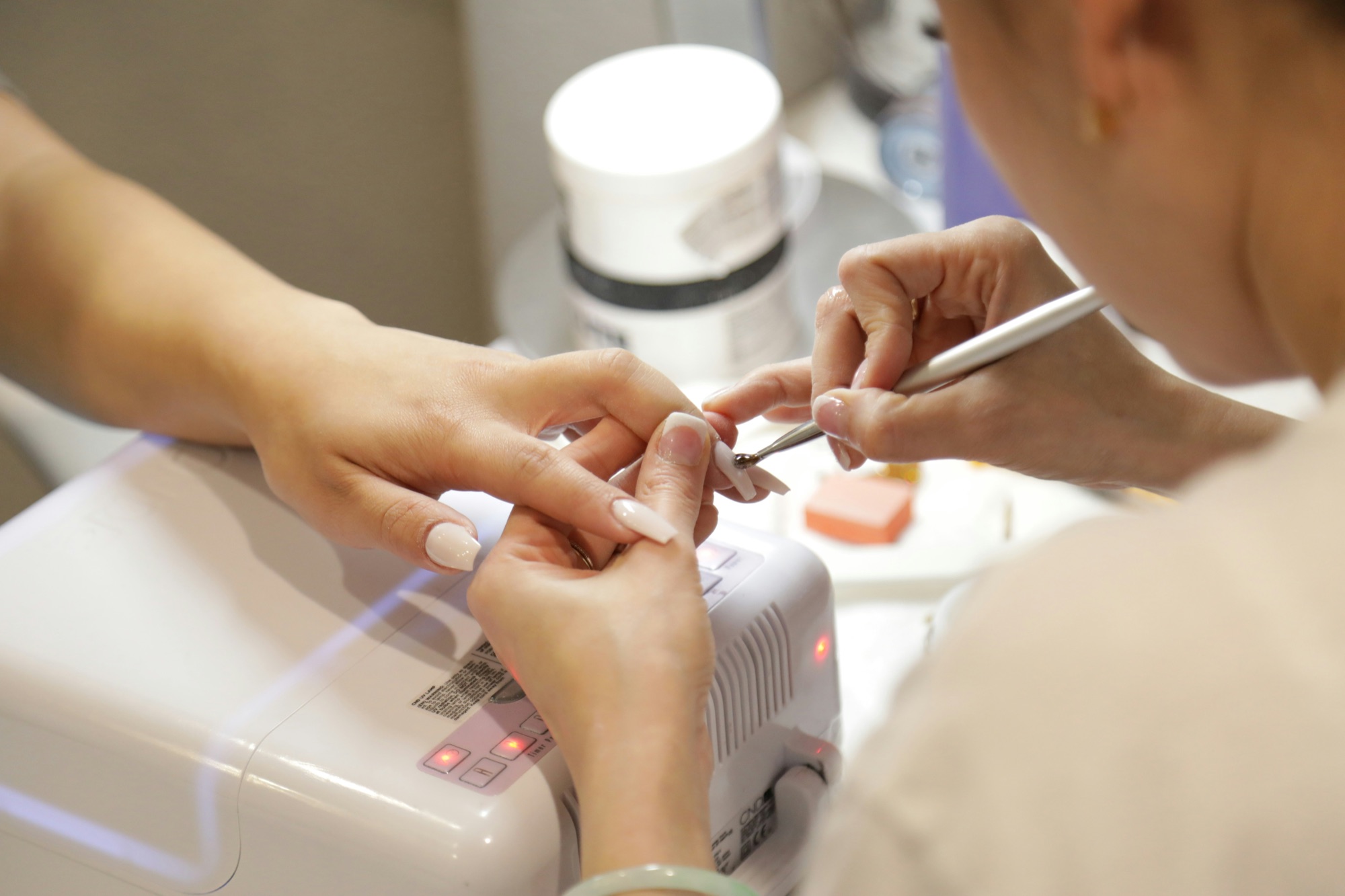 Nail technician caring for a client's hands at Nail Xpress